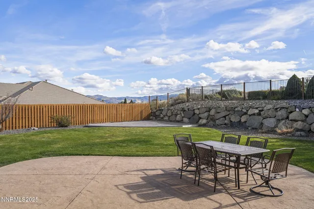 a view of a house with backyard and sitting area