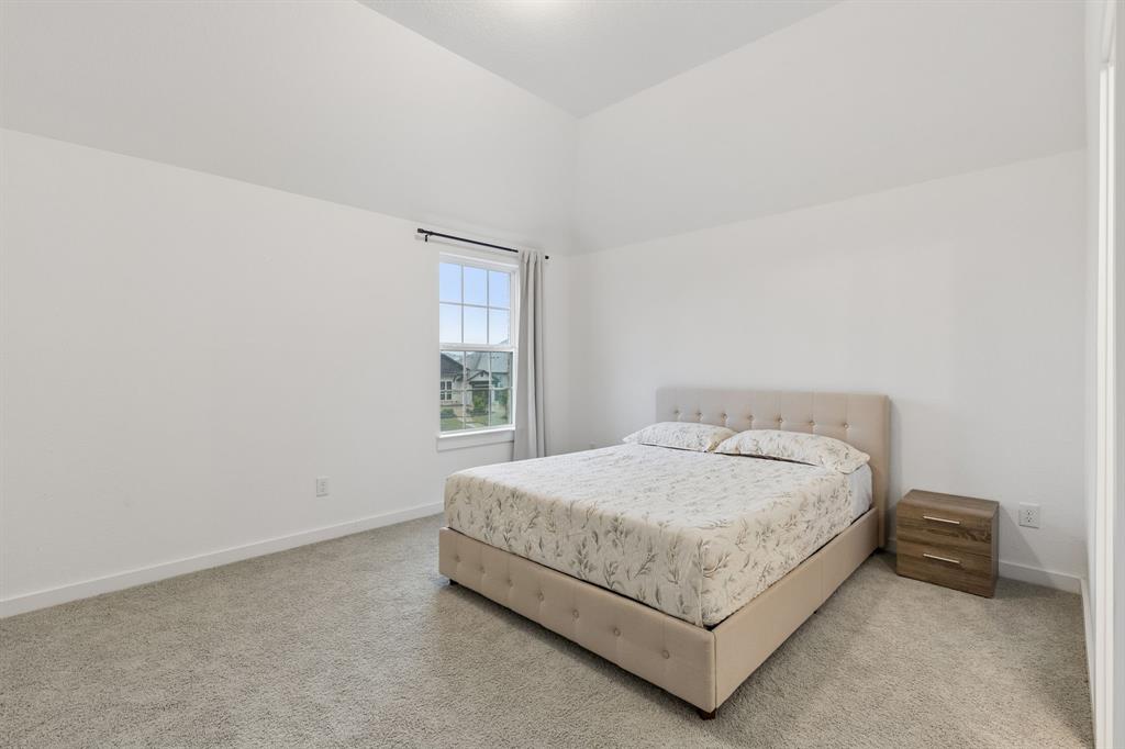566 Broadleaf Way Haslet, TX 76052 - Photo 24 of 38 Spacious room with a vaulted ceiling and neutral carpeting