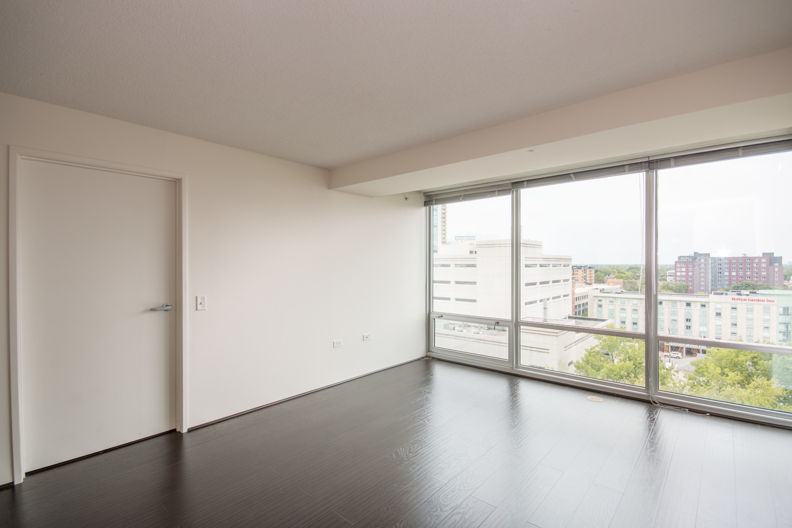 800 Elgin Road, Unit 1206 Evanston, IL 60201 - Photo 8 of 18 an empty room with wooden floor and windows with lake view