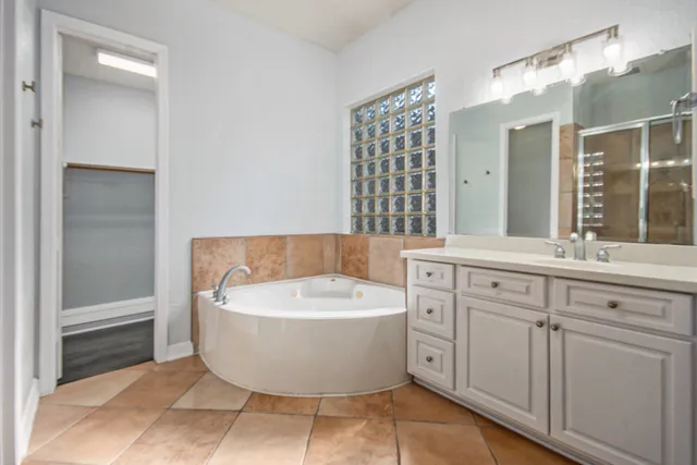 a spacious bathroom with a bathtub sink and mirror