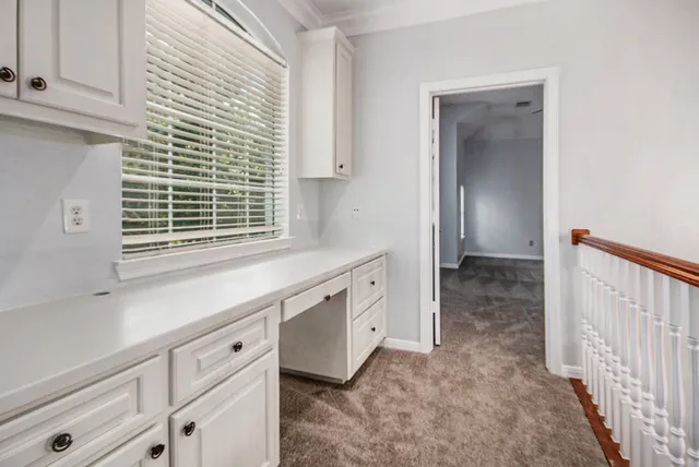 a kitchen with granite countertop white cabinets and window