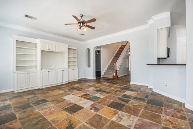 a view of a livingroom with wooden floor and a ceiling fan