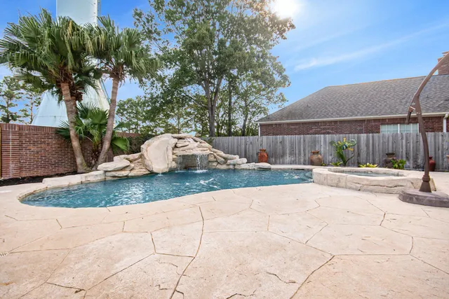 a view of a white house with a small yard and a large tree