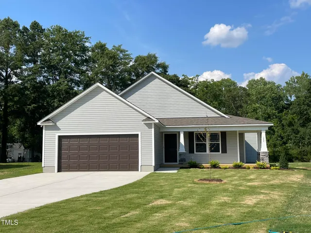 a front view of a house with a garden and yard