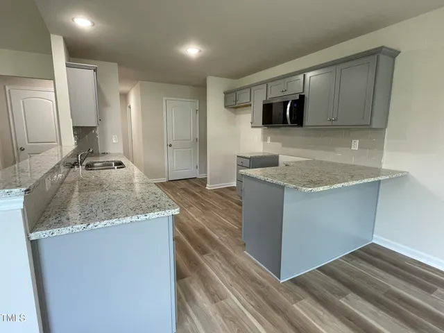 a kitchen with stainless steel appliances granite countertop a sink stove and microwave