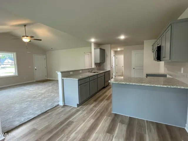 a large kitchen with stainless steel appliances kitchen island a large counter top and a wooden floors