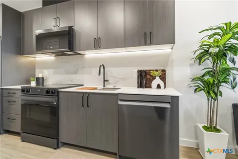a kitchen with stainless steel appliances a stove a sink and a microwave