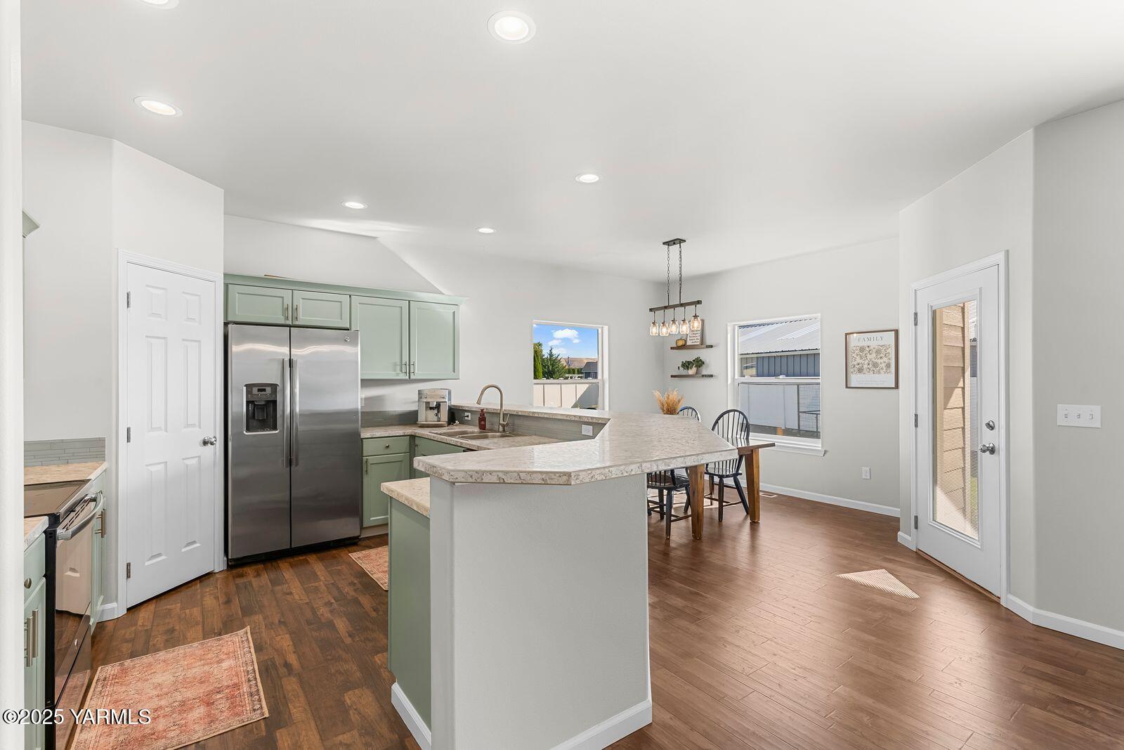 115 Apple Loop Naches, WA 98937 - Photo 13 of 48 a kitchen with a refrigerator a dining table and chairs