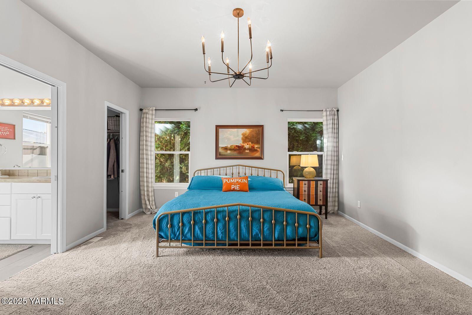 115 Apple Loop Naches, WA 98937 - Photo 22 of 48 a bedroom with a large bed a chandelier and dresser