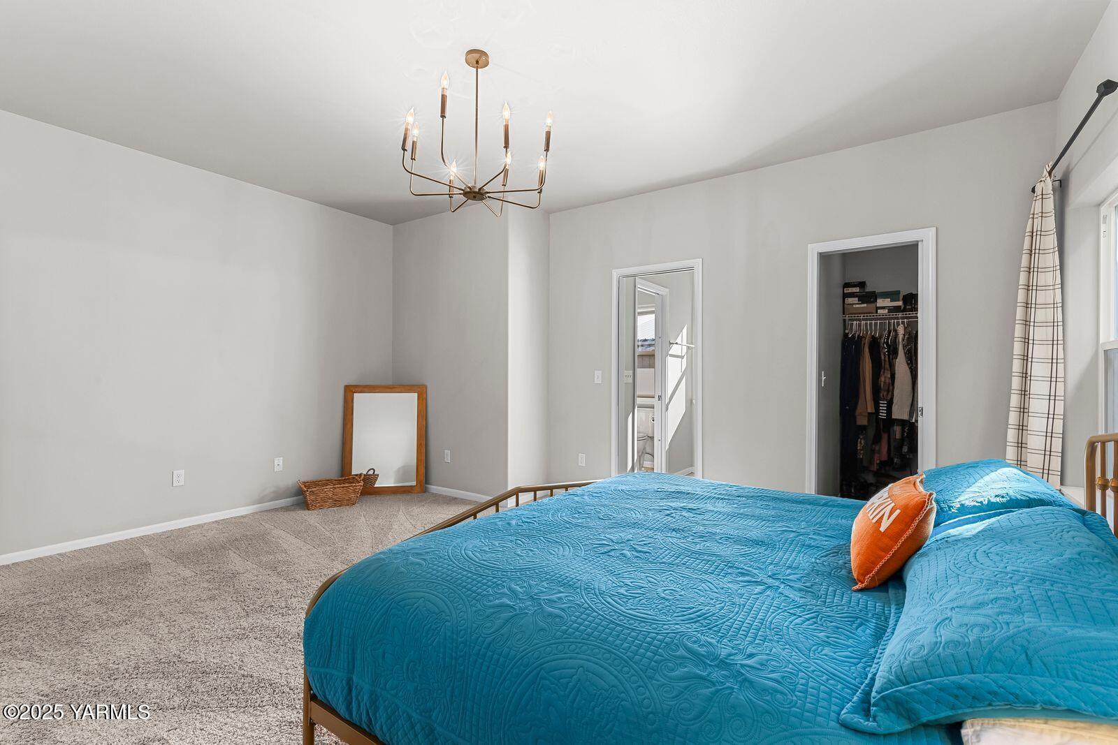 115 Apple Loop Naches, WA 98937 - Photo 23 of 48 a bedroom with a bed and a chandelier