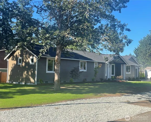 a front view of a house with a garden and trees