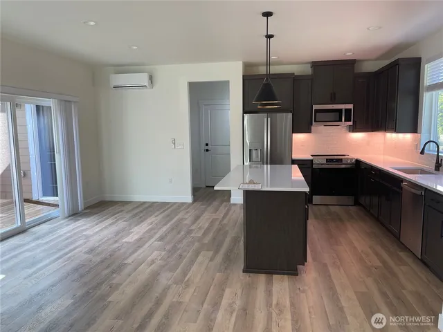 a kitchen with stainless steel appliances granite countertop a refrigerator a sink dishwasher a stove and a microwave oven on granite countertops