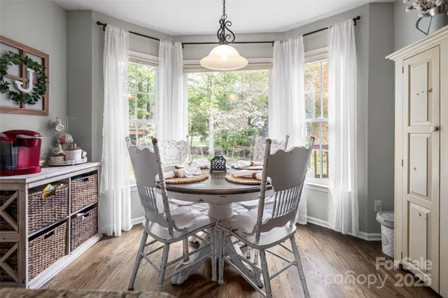 a dining room with furniture large windows and wooden floor