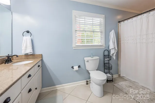 a bathroom with a granite countertop toilet a sink and a mirror