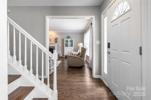 a view of a hallway with wooden floor and stairs