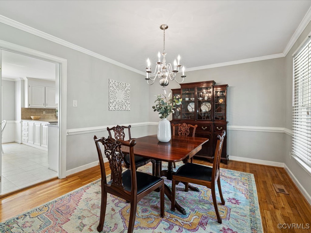 1519 Kingscross Road Midlothian, VA 23114 - Photo 9 of 50 a dining room with furniture wooden floor a rug and a chandelier