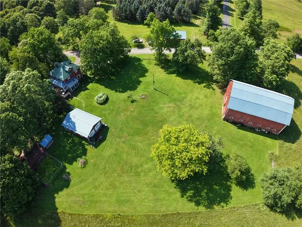 an aerial view of a house with a yard and large trees