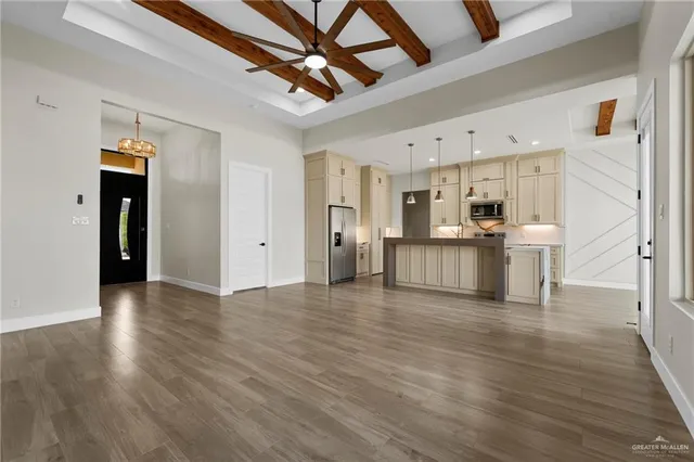 a view of a kitchen with wooden floor and electronic appliances