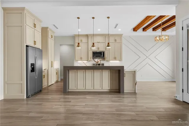 a view of kitchen and empty room with wooden floor