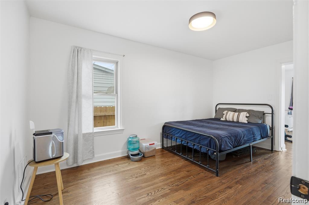 4612 Balfour Road Detroit, MI 48224 - Photo 8 of 20 Bright room featuring wood-finish flooring, a single window with white trim, and a contemporary flush-mount ceiling light