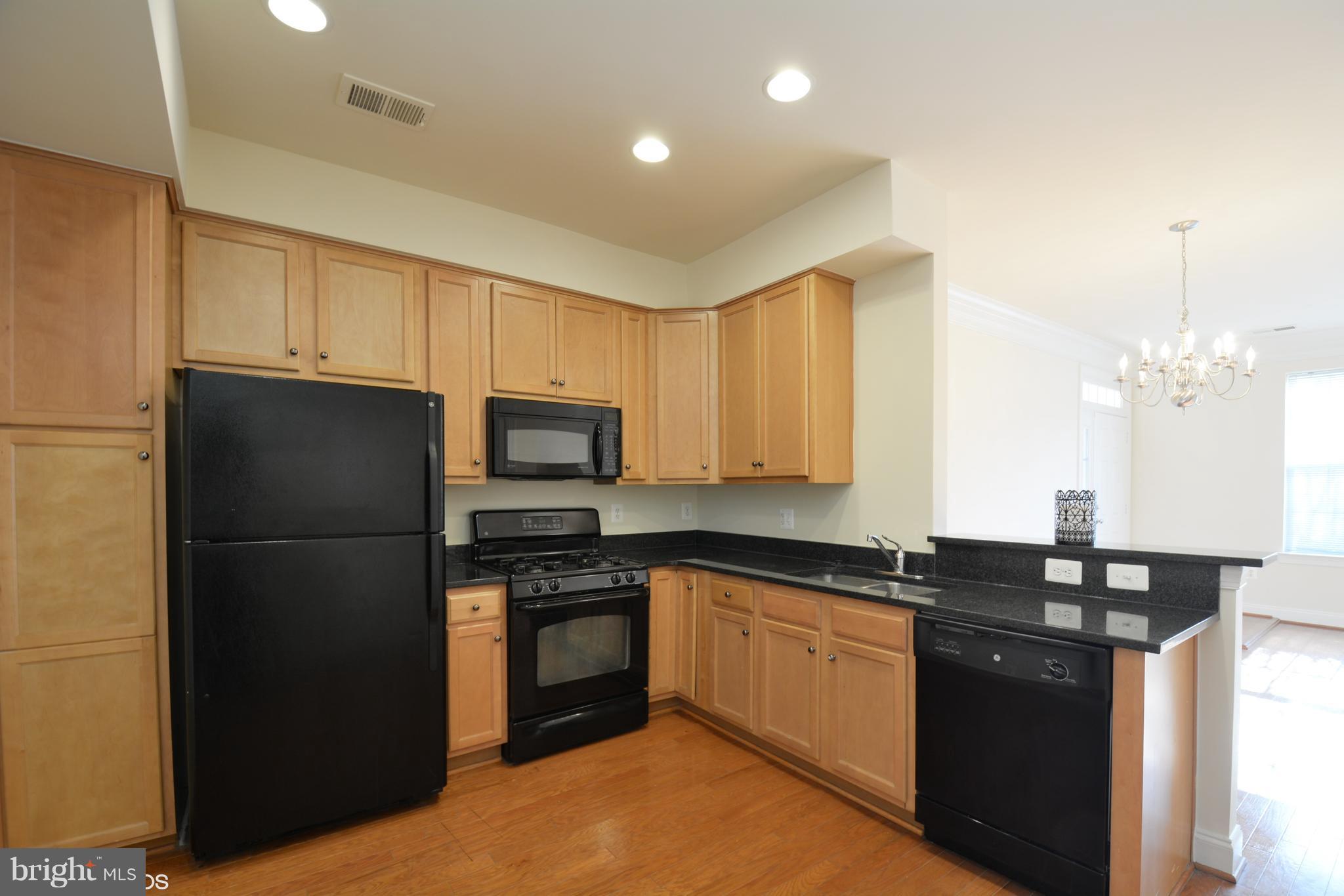4110 Potomac Highlands Circle, Unit 5 Triangle, VA 22172 - Photo 8 of 24 a kitchen with a sink a kitchen island and stainless steel appliances