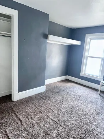 an empty room with windows and closet