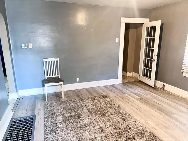 a view of a bedroom with wooden floor and a bench