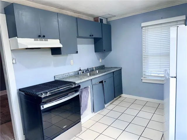 a kitchen with a sink stove and cabinets