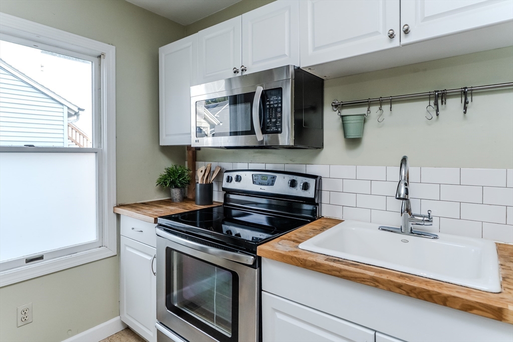 9 Walnut Street, Unit B Northampton, MA 01060 - Photo 13 of 25 a kitchen with stainless steel appliances granite countertop a sink and a stove
