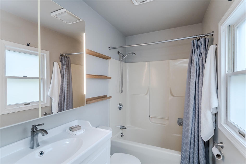 9 Walnut Street, Unit B Northampton, MA 01060 - Photo 9 of 25 a bathroom with a bathtub shower sink vanity and a toilet