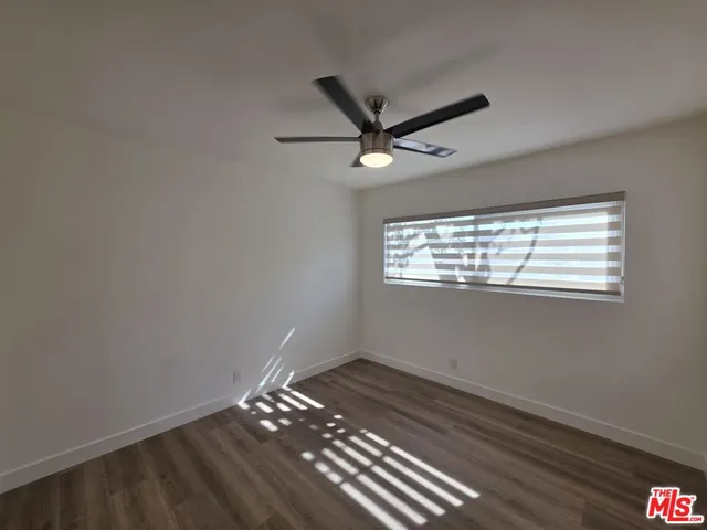 a view of a hallway with wooden floor and a livingroom