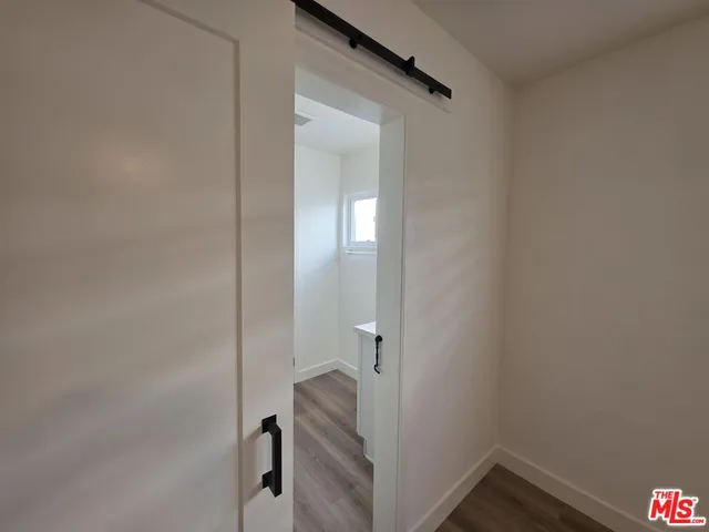 a view of a room with wooden floor a ceiling fan and window
