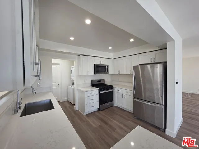 a kitchen with a refrigerator stove and wooden floor