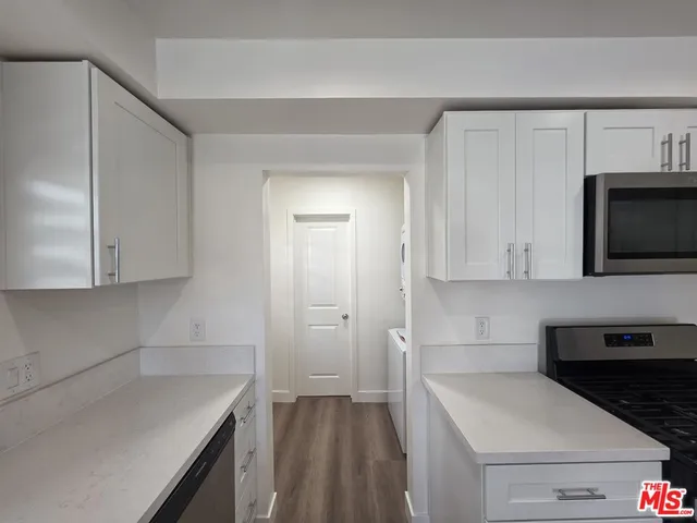 a view of empty room with wooden floor and fireplace