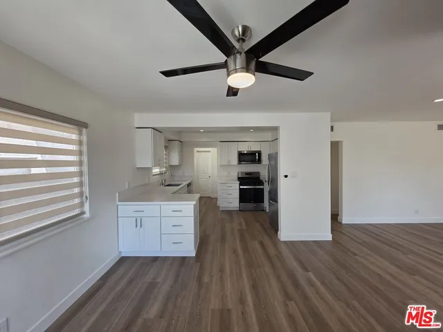 a living room with stainless steel appliances wooden floor and a fireplace