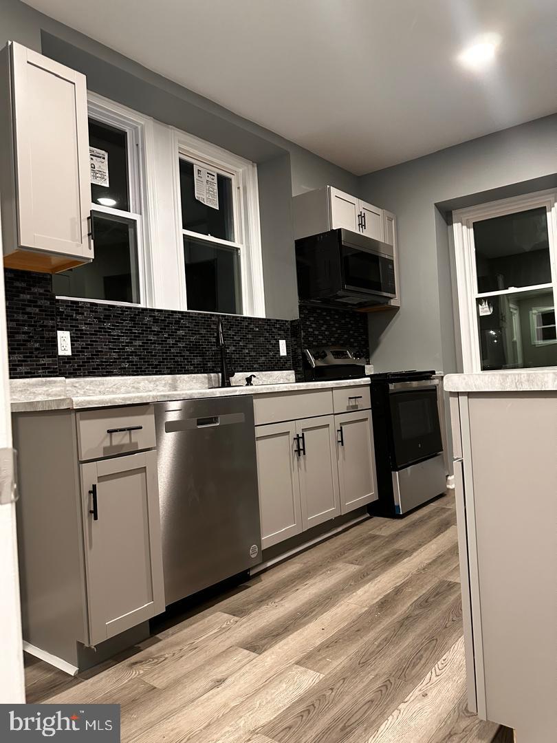 32 Kent Road Upper Darby, PA 19082 - Photo 17 of 60 a kitchen with stainless steel appliances granite countertop a stove a sink and a microwave