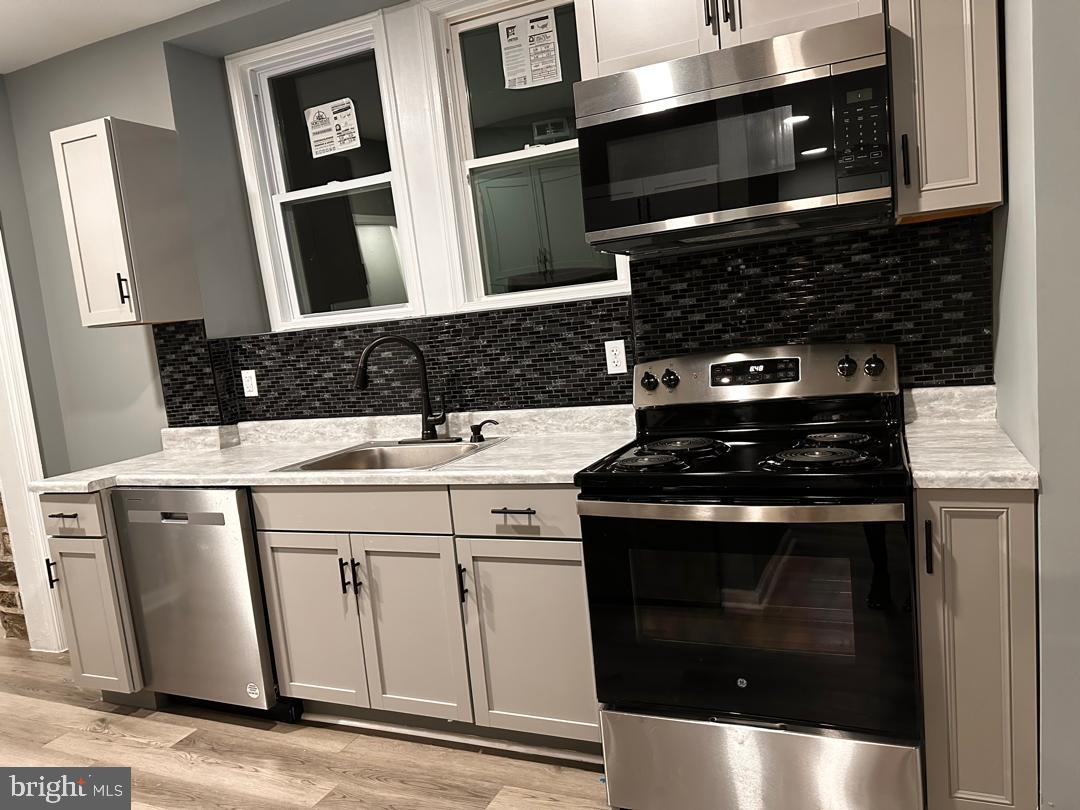 32 Kent Road Upper Darby, PA 19082 - Photo 21 of 60 a kitchen with a stove and a microwave
