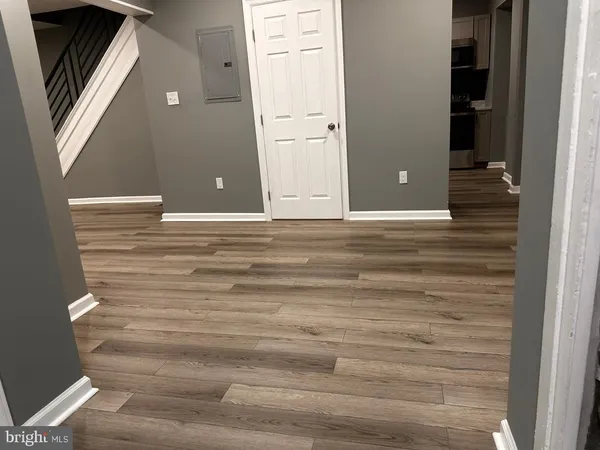 a view of an empty room with wooden floor and windows