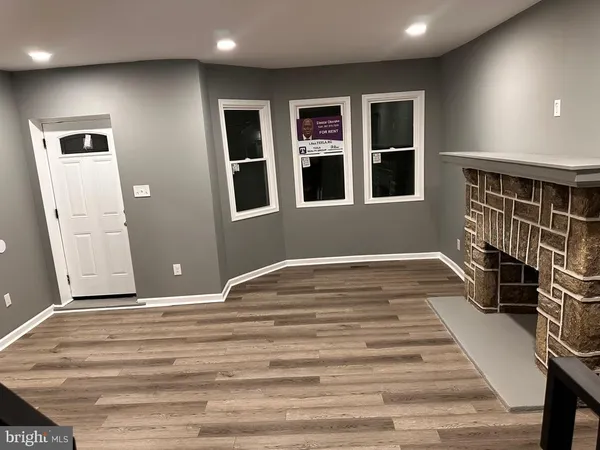 a view of an empty room with wooden floor and closet