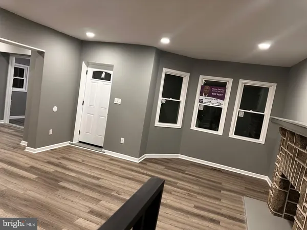 a view of an empty room with wooden floor and staircase