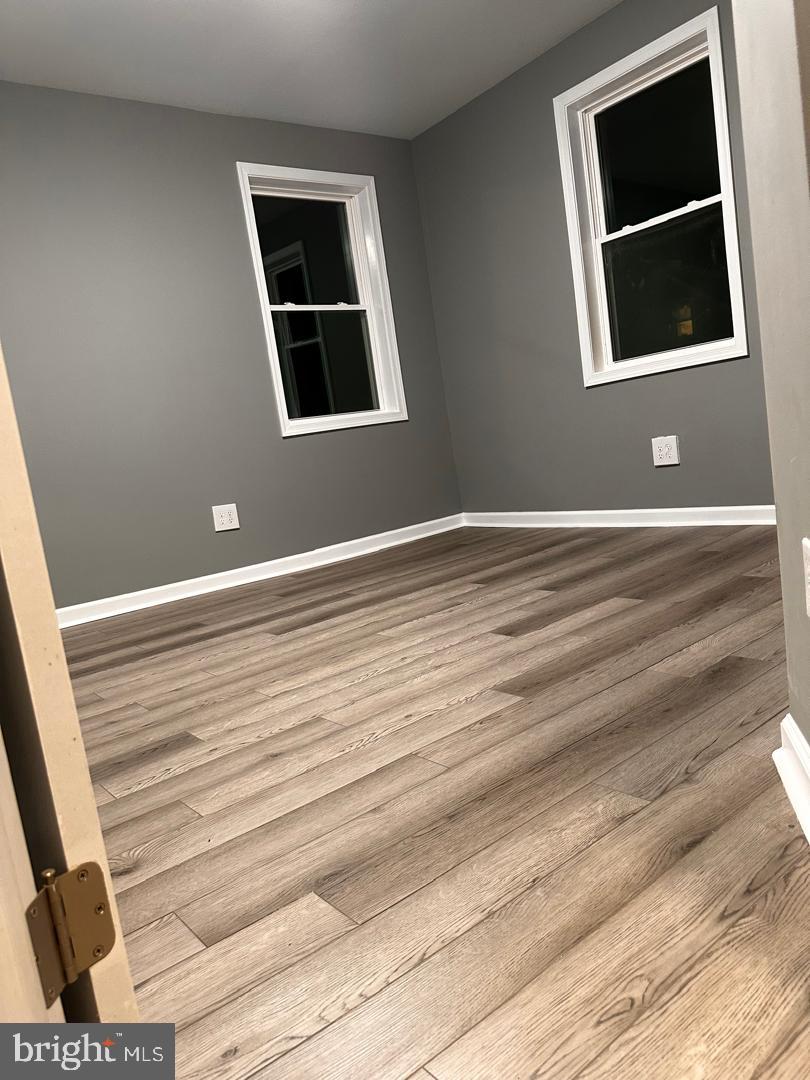 32 Kent Road Upper Darby, PA 19082 - Photo 39 of 60 a view of an empty room with wooden floor and windows