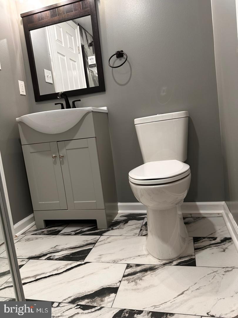 32 Kent Road Upper Darby, PA 19082 - Photo 56 of 60 a bathroom with a toilet mirror on vanity and a sink