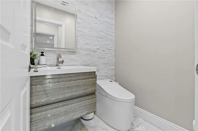 a bathroom with a sink toilet and mirror