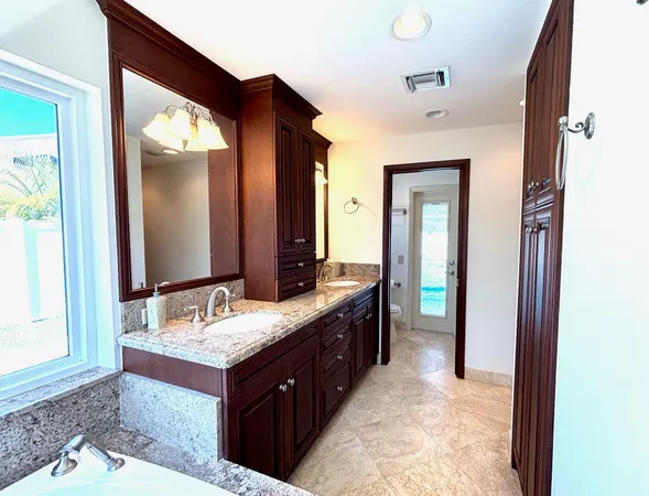 a bathroom with a granite countertop sink and a mirror