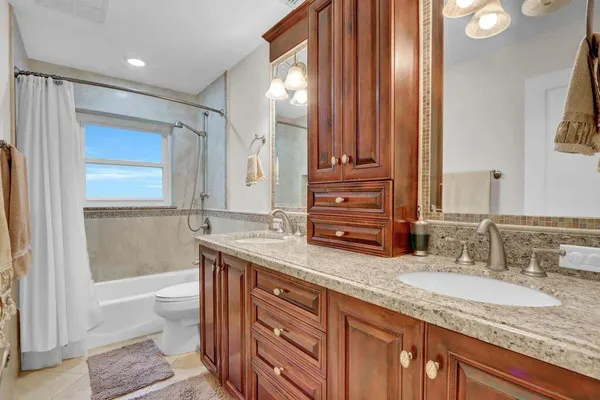 a bathroom with a granite countertop sink double vanity and a mirror