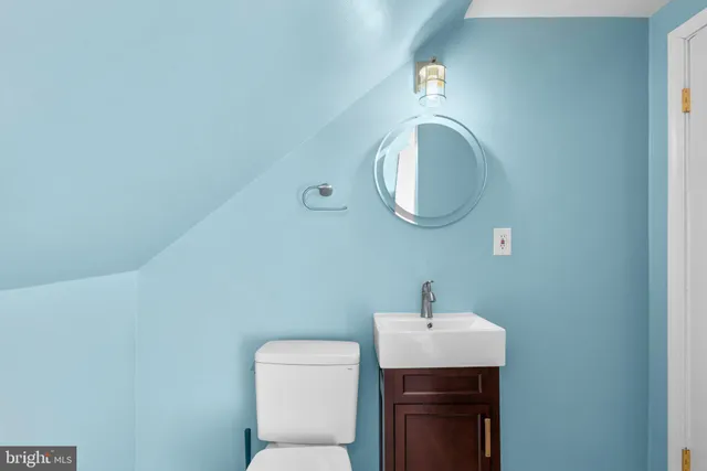 a bathroom with a toilet a sink and mirror