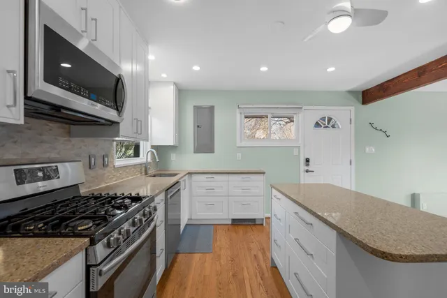 a kitchen with stainless steel appliances a stove a sink and a microwave