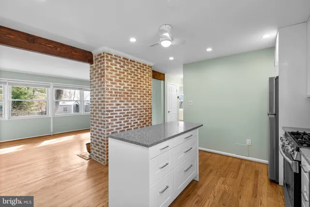a kitchen with granite countertop white cabinets and wooden floor