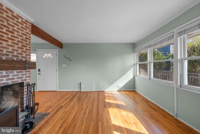 a view of empty room with wooden floor and fireplace