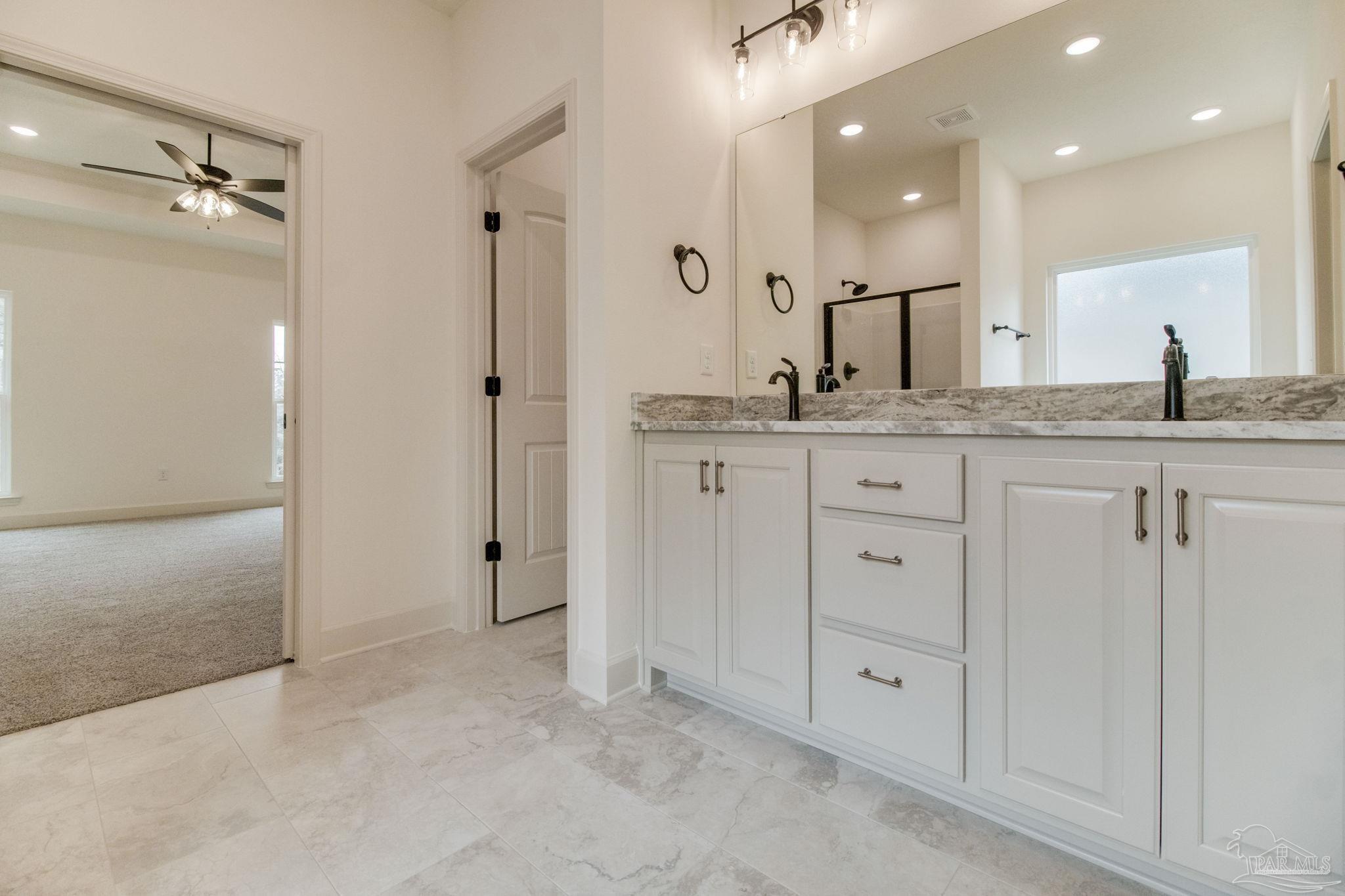 4310 Watkins Street Pace, FL 32571 - Photo 43 of 58 a large white bathroom with a granite countertop sink mirror and shower